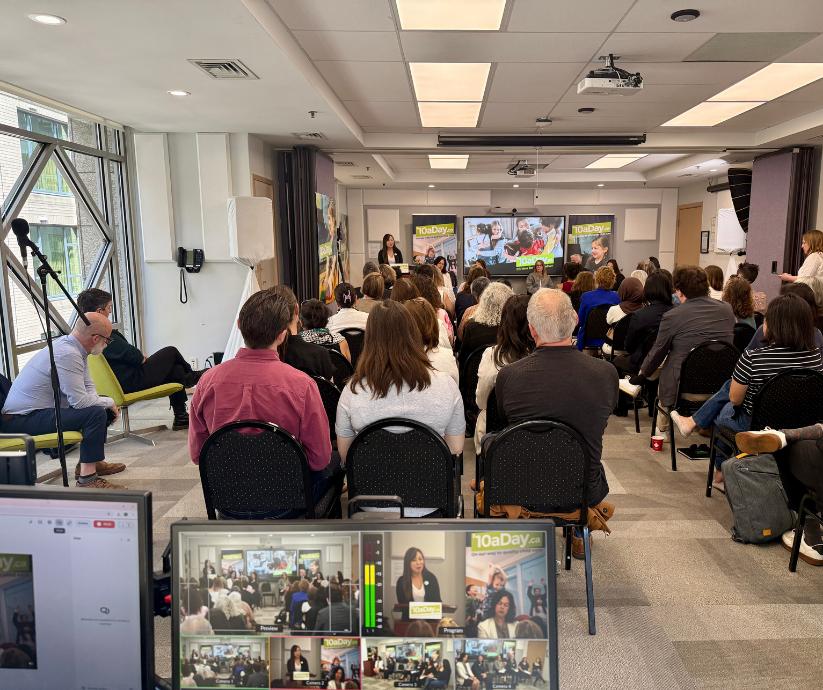 Professional AV team operating livestream monitors and camera equipment while audience watches speaker at Vancouver advocacy event