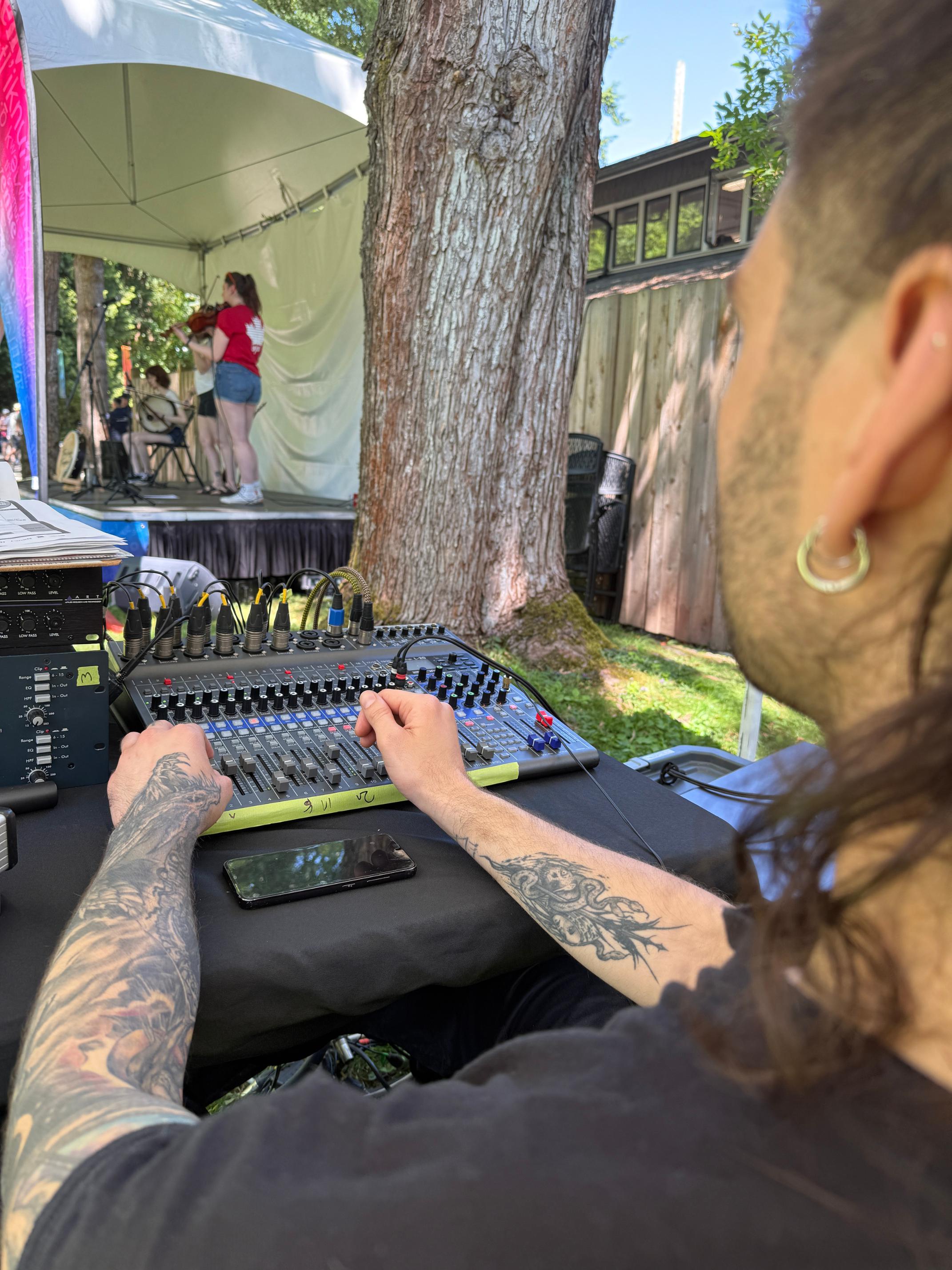 Stage preparation with audio visual crew managing live sound and lighting for Burnaby’s Canada Day celebration.